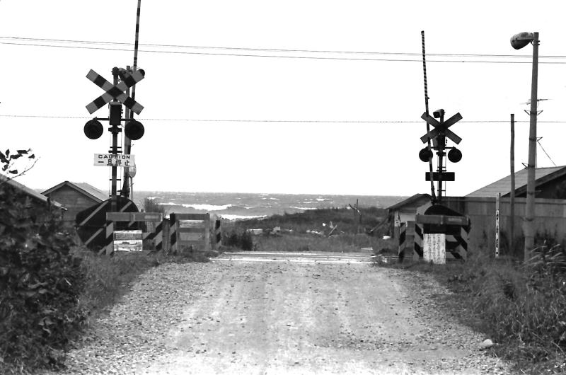 海岸へ向かう砂利の道路。内浦湾の荒い波が押し寄せています。