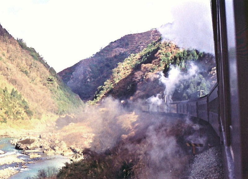 山陰本線保津峡・馬堀間を行く。蒸気機関車の白い煙がたなびく。