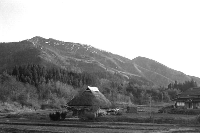 芸備線　道後山付近。古びた民家と雪が残った山。　昭和４６（１９７１）年３月