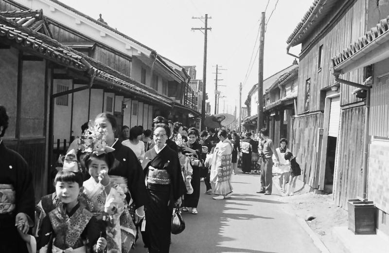 どこへ向かうのか、晴れ着姿の親子の列