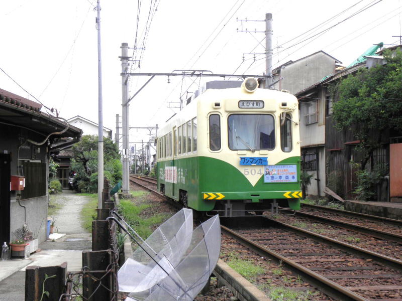 干し傘の横を通り抜ける、恵美須町行き阪堺電車。