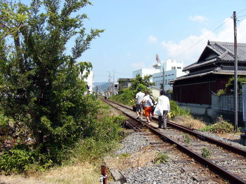 線路を歩く線路端に玄関がある家の人たち