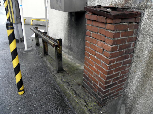 盛り上がった道路にあるレールの柵