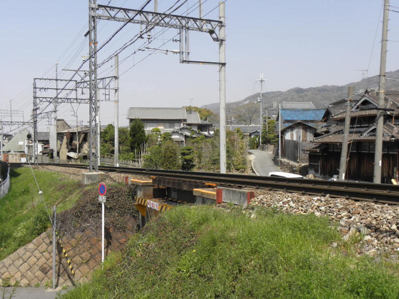 新旧の住宅と植え木の間に伸びる線路。