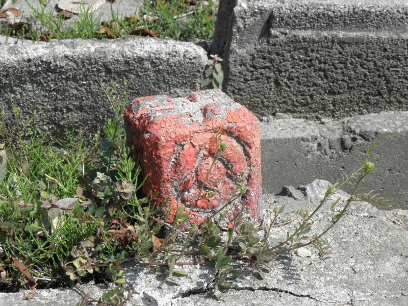 年季を感じさせる線路境界表示。近鉄のマーク。