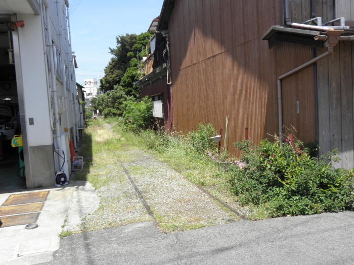 建物の間をのびて来る廃線跡